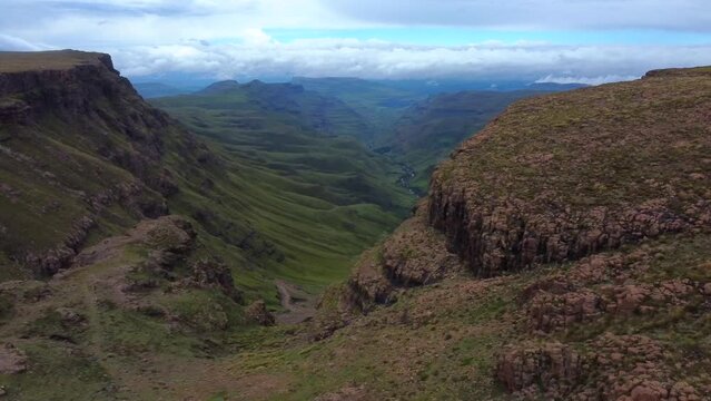 Drone shot of Drakensberg in South Africa - drone is on top of the mountain and revealing Sani Pass valley. Snippet could ideally be used for travel related videos or hiking movies.