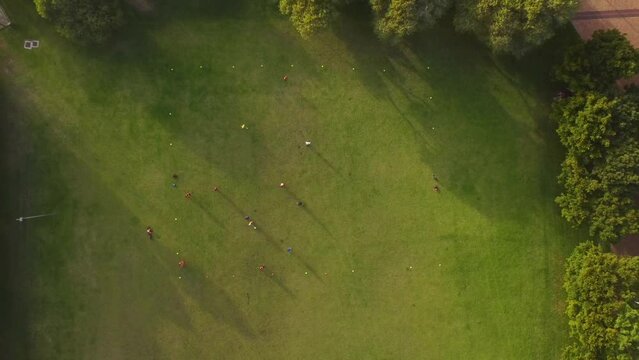 Birds eye drone shot of Green Point Park in Cape Town - drone is ascending over athletes playing football. Snippet could ideally be used for sports related videos or a Cape Town movie.