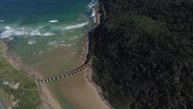 Birds eye drone shot of Wilderness beach in South Africa - drone is circling around the old railway bridge. Snippet could ideally be used for travel or hiking related videos or South Africa movies.