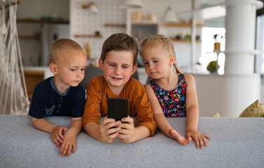 Childhood technology kids smartphone concept. Happy little children playing on mobile phone