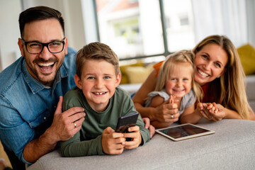 Happy family spending time at home with digital devices together. Technology people fun concept.