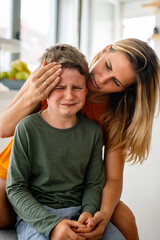 Portrait of mother consoling her crying sad injured son. Child family support parent concept