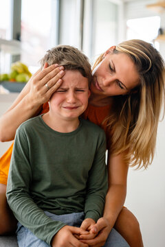 Portrait of mother consoling her crying sad injured son. Child family support parent concept