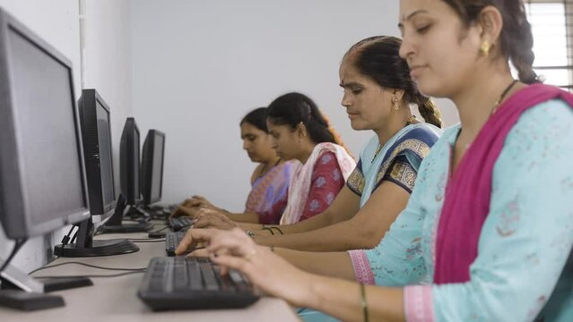 group of women busy learning or working on computer at training center - concept of empowerment, learning and education