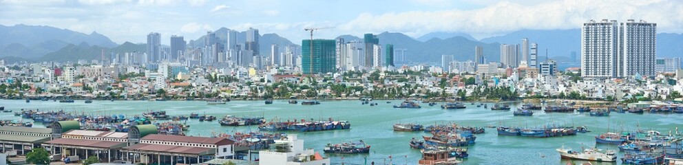 Fototapeta na wymiar Panoramic view of tourist city of Nha Trang off coastline with fishing boats. Khanh Hoa province, Viet Nam