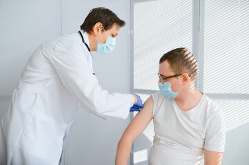 Obraz premium Female doctor vaccinating a man