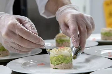 Foto op Canvas chef plating food only hand showing in low light with grain and out of focus © ca