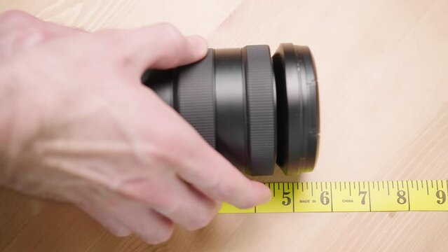 Person with measuring tape measure size of camera lens zoom 4K