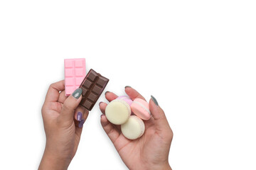 Woman hand holding colorful pastel macaroons and chocolate bars isolated on white background.