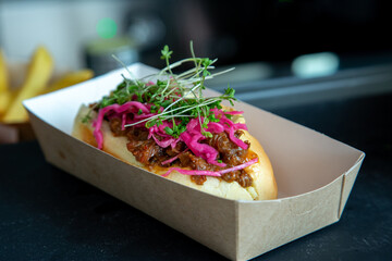 pulled beef on roll with pink pickled onion low light with grain and out of focus
