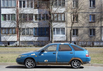An old rusty blue car is parked on the street, Chudnovsky Street, St. Petersburg, Russia, April 2022