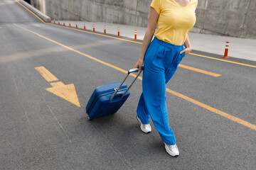 woman moving on road with suitcase