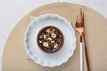 luxury home baked rocher dark rich chocolate tart in 3 layer with hazelnut mixed nuts and gold foil in white background halal dessert menu for hotel cafe