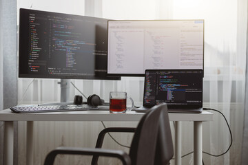 Interior shot. Workplace of a programmer, IT job, home, Computer monitors and laptop on desk