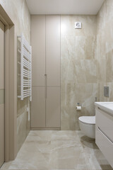bathroom with beige tiles with stone texture, interior of a modern apartment