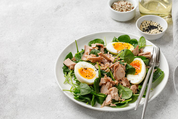 Tuna salad with boiled egg and spinach on white plate. Keto diet, healthy food. Fresh salad bowl. Dinner.