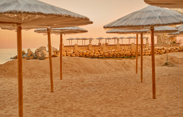 Straw umbrellas from the sun on a deserted beach. 