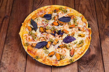 Baked pizza with mussels on the old rustic wooden table