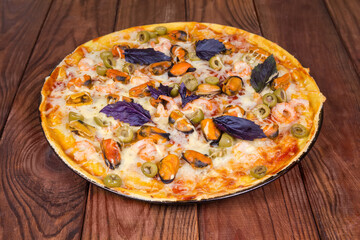 Baked pizza with seafood on the old rustic wooden table