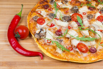 Part of pizza with chicken meat on wooden cutting board
