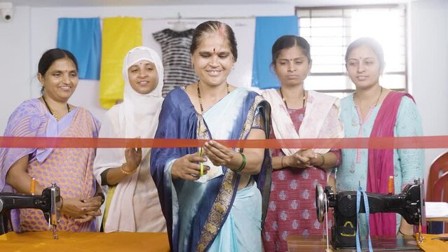 Indian Woman Starting New Garments Or Tailoring Small Business By Ribbon Cutting While Workers Clapping From Behind - Concept Of Inspiration, Diversity And Empowerment.