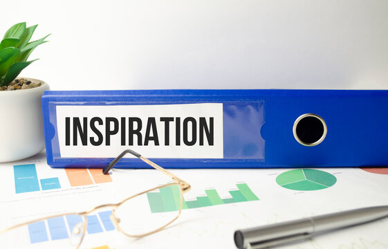 Inspiration concept. Word on the blue folder and charts