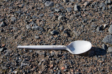 white plastic spoon on the ground