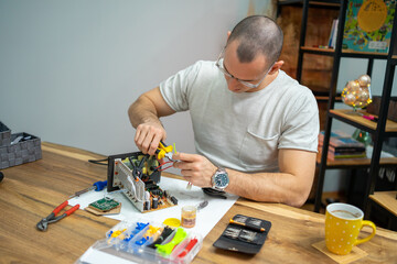 The young master electronics engineer checks, repairs and finishes the motherboard he was given to...