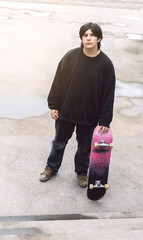 Teenager with a skateboard on the side