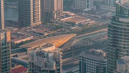 Futuristic buildings of Dubai with metro station and luxury skyscrapers behind near Dubai Marina timelapse