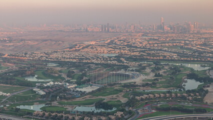 Aerial view to Golf course with green lawn and lakes, villas and houses behind it timelapse.