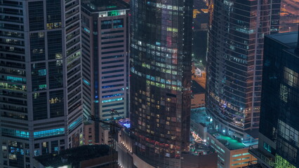Modern buildings with blue stained glass windows glowing at night in Dubai Media City timelapse, United Arab Emirates