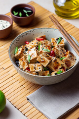 Naklejka premium Tofu in teriyaki sauce with green onions, chili peppers and sesame. Asian food. Vegetarian food. Healthy eating.