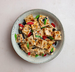 Tofu in teriyaki sauce with green onions, chili peppers and sesame. Asian food. Vegetarian food. Healthy eating.