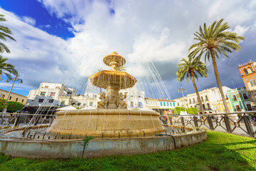 Fototapeta na wymiar Mérida, Spain. April 28, 2022. View of the Spain Square. The square shows a neo-baroque marble fountain from the end of the 19th century, made at the workshop of Germano José do Salles