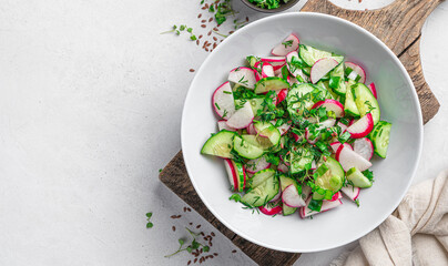 A healthy salad with radishes and herbs on a light background with a space to copy. Diet salad.