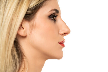 Profile portrait of a young woman with a humpbacked nose on a white background