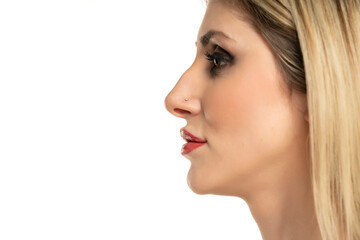Profile portrait of a young woman with a humpbacked nose on a white background