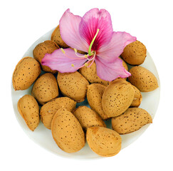 Fresh Almond nuts and purple orchid tree flower isolated on white. Almendra.
