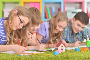 Fototapeta premium Portrait of group of children drawing with pencils