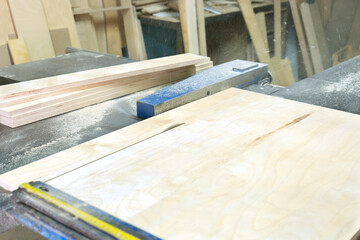 Obraz premium Close-up of cutting wood on a circular saw in a joinery. Furniture manufacture.