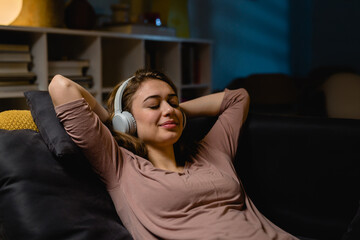 Obraz premium woman relaxing on sofa and listening music