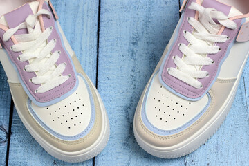 New colored sneakers close-up on a colored wooden background. Fashion footwear. Top view.