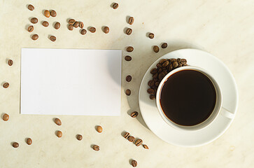 A cup of coffee with coffee beans and empty blank on the table.Top view, mock up