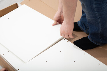 Assembly cabinet furniture. Do it youself concept. White chipboard interior
