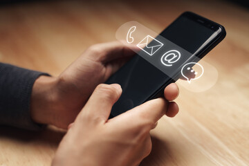 Customer support hotline Contact us people connection. Businessman using smartphone with the email, call phone, address, Chat message icons.