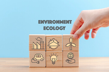 Circular economy concept, recycle, environment, reuse, manufacturing, waste, consumer, resource. Sustainable development. Hand put wooden cubes; the symbols of circular economy on blue background.