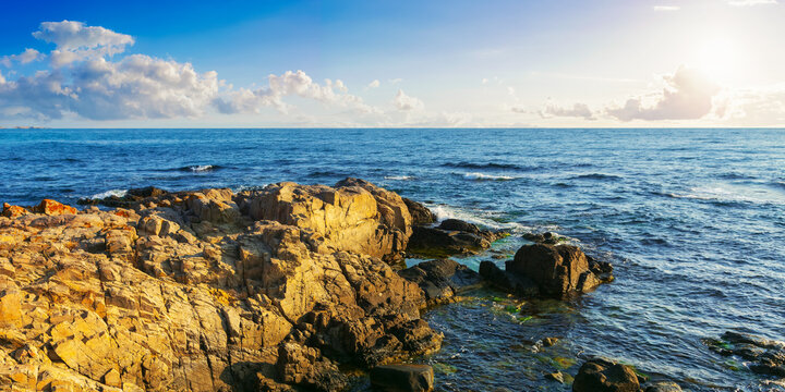 rocky sea coast in morning light. summer vacation concept. beautiful nature scenery with clouds on the blue sky above horizon