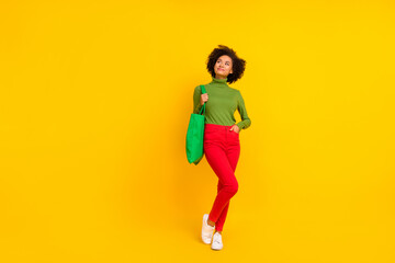 Fototapeta na wymiar Full body photo of young cheerful girl dream think curious look empty space shopping isolated over yellow color background