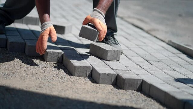 workers lay paving tiles, construction of brick pavement, close up architecture background, slow motion